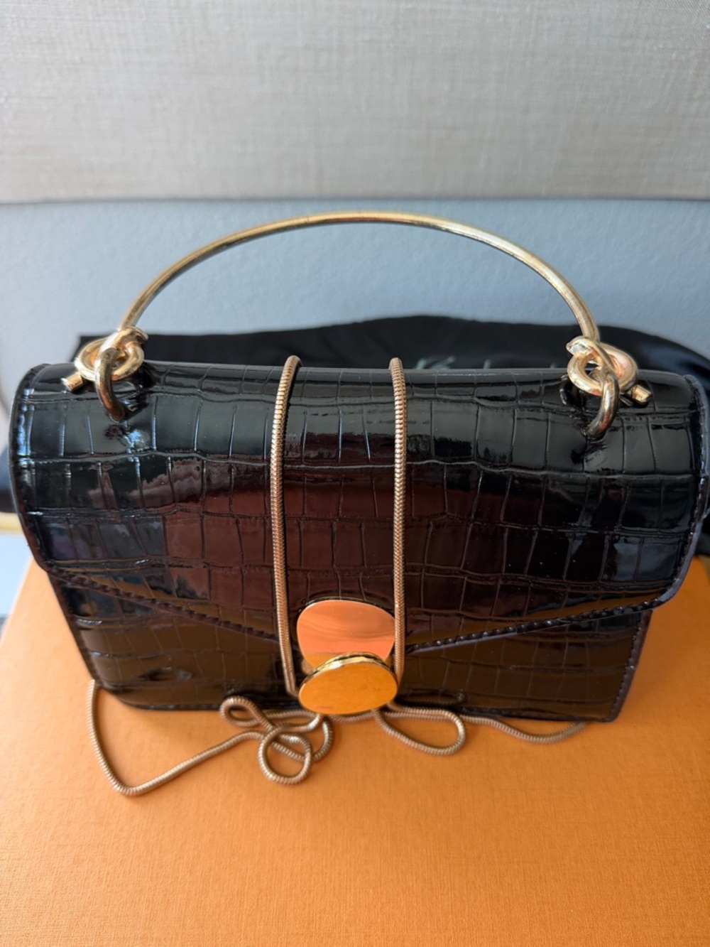A Black Handbag with Golden Chain Shoulder Strap